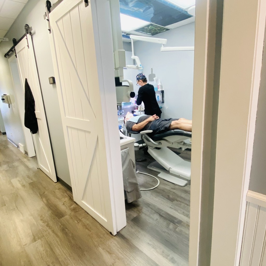 a dental assistant working on a patient.
